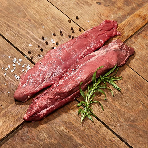 Innerfilé från svensk dovhjort på träbord med kvist och salt