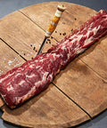 Ytterfilé från svensk björn på träplatta med kniv och salt